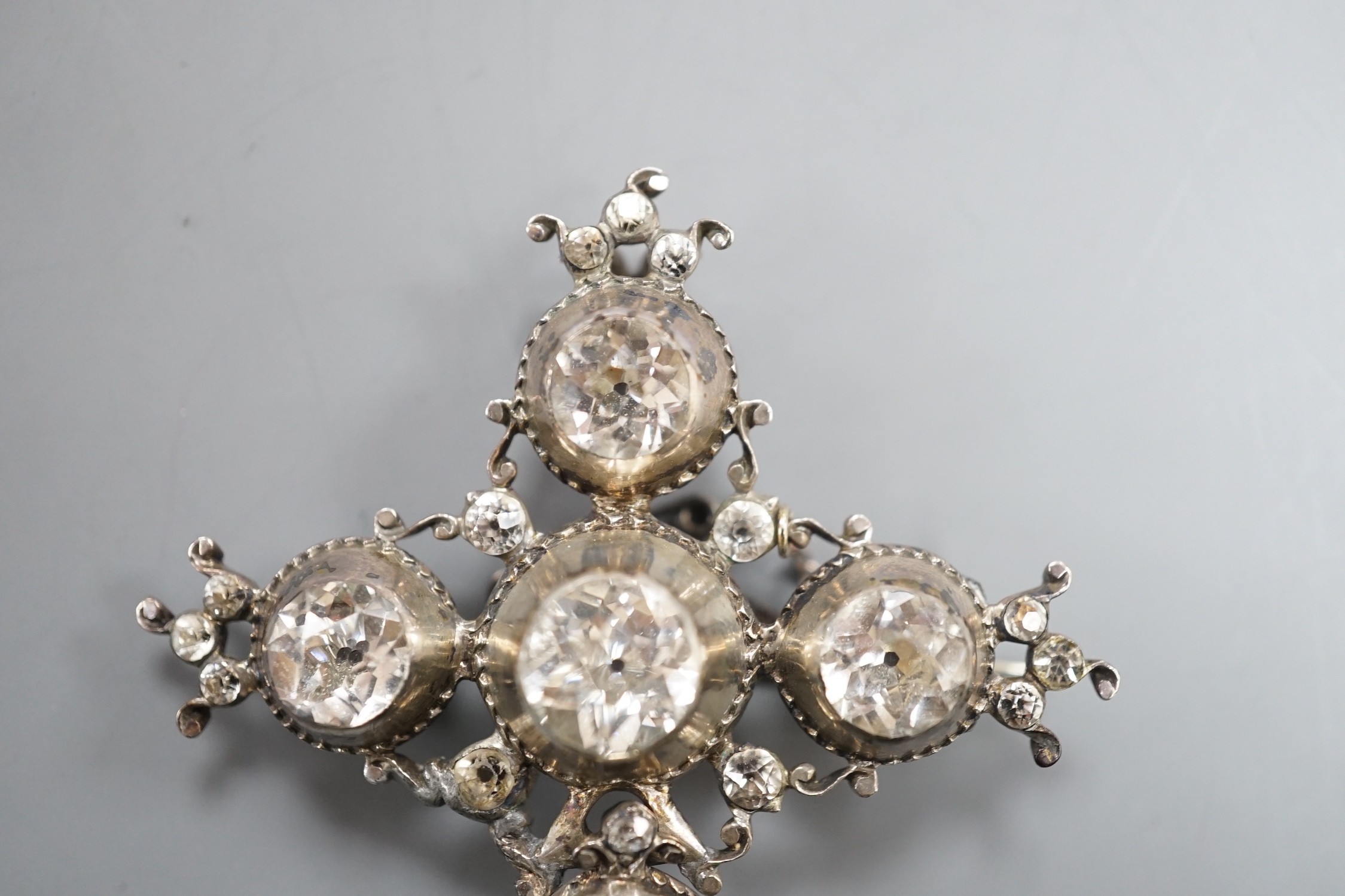 A 19th century white metal and paste cluster set quatrefoil shaped pendant brooch, 56mm, (a.f.).